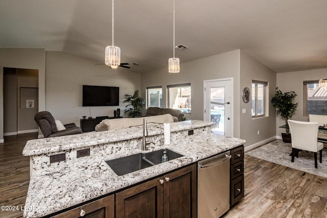 kitchen featuring vaulted ceiling, sink, a kitchen island with sink, and dark brown cabinetry