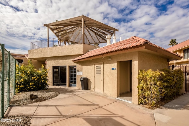 1650 Smoketree Ave S Unit 119, Lake Havasu City, AZ 86403 - rear view of property featuring fence, a balcony, a patio, stucco siding, and a tile roof