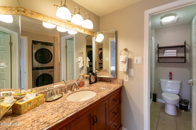 1650 Smoketree Ave S Unit 119, Lake Havasu City, AZ 86403 - bathroom with vanity, visible vents, toilet, stacked washing maching and dryer, and tile patterned floors