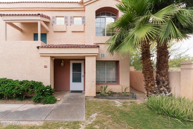 1650 Smoketree Ave S Unit 119, Lake Havasu City, AZ 86403 - doorway to property with visible vents, stucco siding, a tile roof, and fence