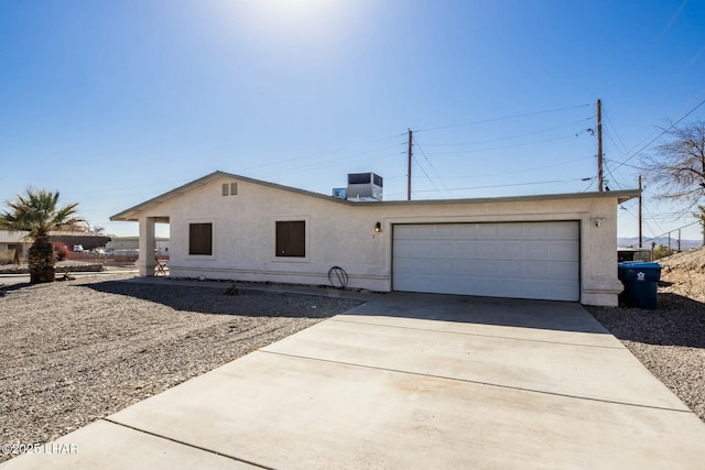 view of front of property with central AC unit and a garage