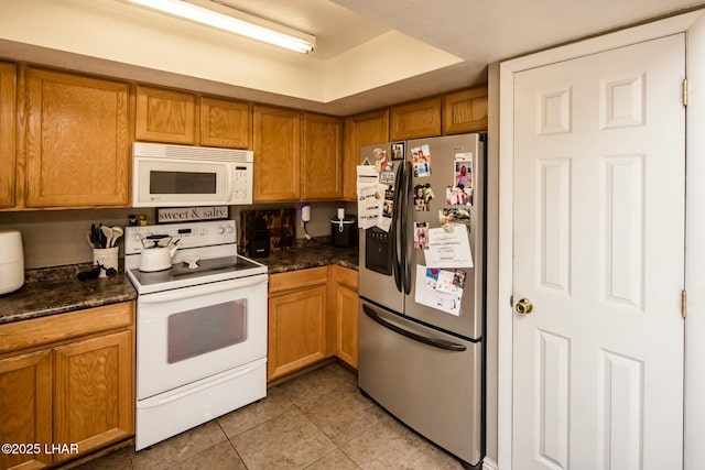 kitchen with white appliances and light tile patterned flooring