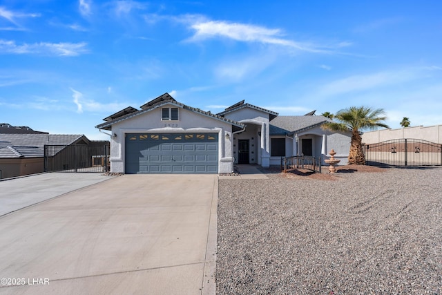 view of front facade featuring fence, an attached garage, driveway, and a gate