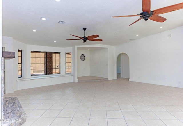 unfurnished living room with light tile patterned floors, a textured ceiling, and ceiling fan