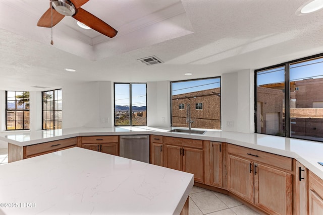 kitchen featuring sink, light tile patterned floors, ceiling fan, a textured ceiling, and stainless steel dishwasher