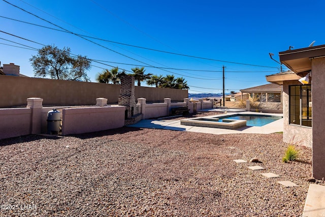 view of yard with a swimming pool with hot tub and a patio area