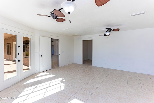 tiled empty room featuring french doors and ceiling fan