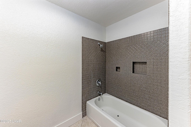 bathroom with tile patterned floors, tiled shower / bath combo, and a textured ceiling