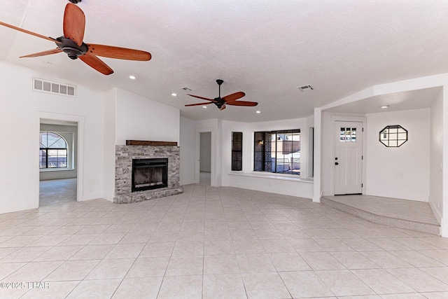 unfurnished living room featuring light tile patterned floors, a fireplace, a textured ceiling, and ceiling fan