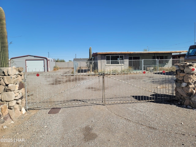 view of front facade featuring a garage, an outbuilding, concrete driveway, and fence