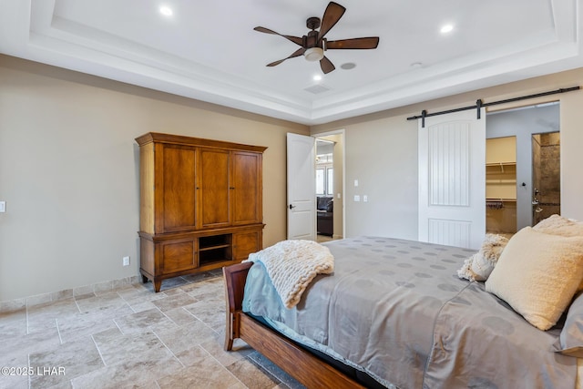 1589 Park Terrace Ave, Lake Havasu City, AZ 86404 - bedroom with a barn door, baseboards, stone finish flooring, a tray ceiling, and a walk in closet