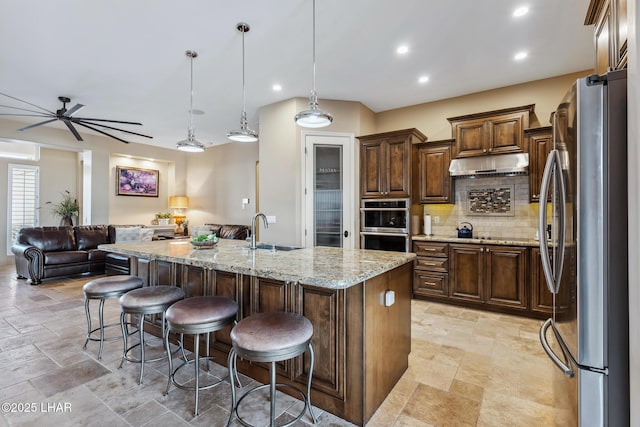 1589 Park Terrace Ave, Lake Havasu City, AZ 86404 - kitchen with appliances with stainless steel finishes, open floor plan, hanging light fixtures, light stone countertops, and a kitchen island with sink