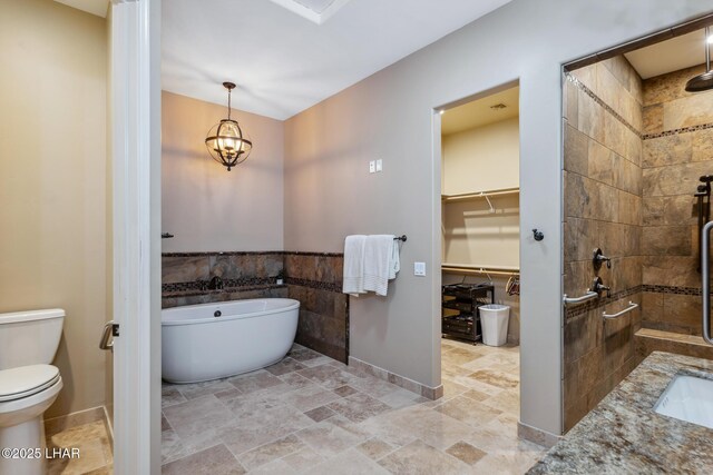 1589 Park Terrace Ave, Lake Havasu City, AZ 86404 - bathroom featuring tile walls, a freestanding bath, toilet, a stall shower, and stone finish flooring
