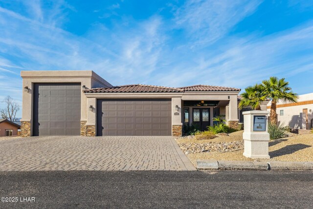 1589 Park Terrace Ave, Lake Havasu City, AZ 86404 - view of front facade with an attached garage, stone siding, decorative driveway, and stucco siding
