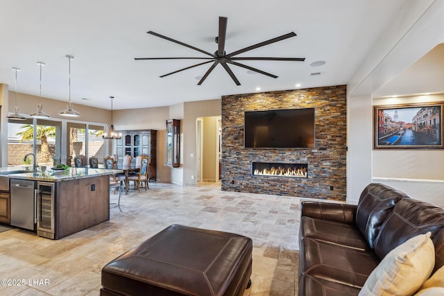 1589 Park Terrace Ave, Lake Havasu City, AZ 86404 - living room featuring stone finish flooring, a fireplace, beverage cooler, and ceiling fan with notable chandelier