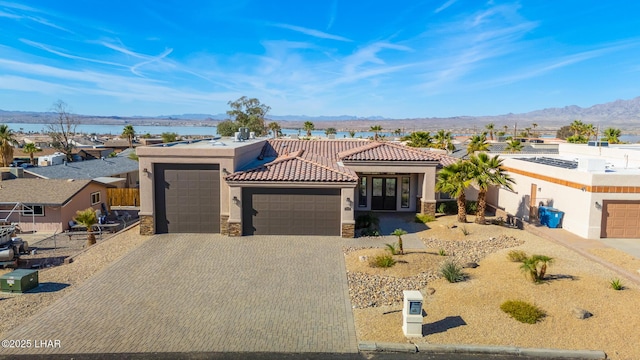 1589 Park Terrace Ave, Lake Havasu City, AZ 86404 - view of front of property featuring an attached garage, a mountain view, stone siding, decorative driveway, and stucco siding