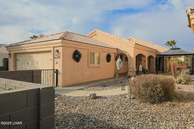 view of front of property featuring a garage and a gazebo