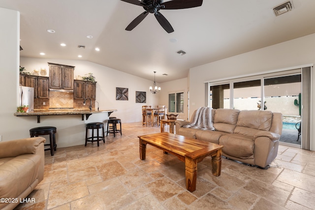 living room featuring vaulted ceiling and ceiling fan with notable chandelier