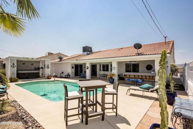 view of pool featuring a hot tub, a fenced in pool, fence, a patio area, and central AC