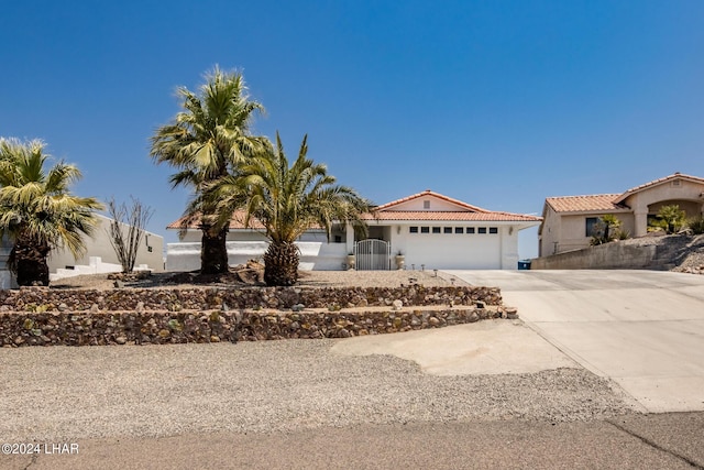 view of front facade with concrete driveway, a tiled roof, an attached garage, and stucco siding