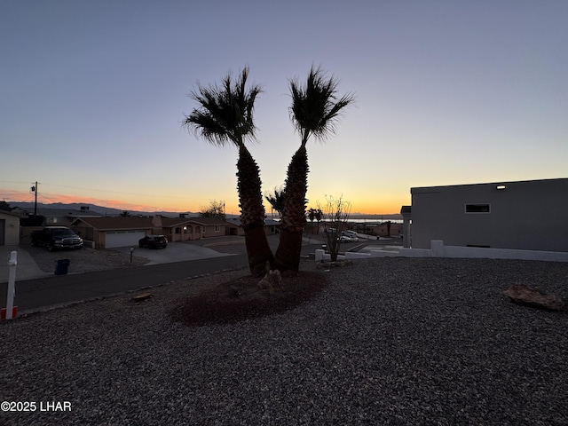 yard at dusk featuring a garage