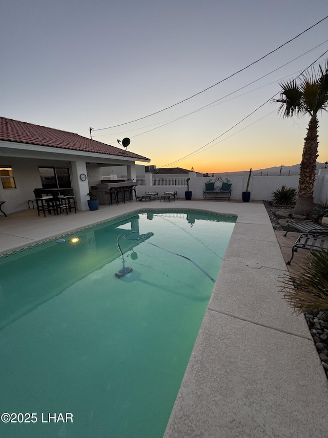 pool at dusk with a patio