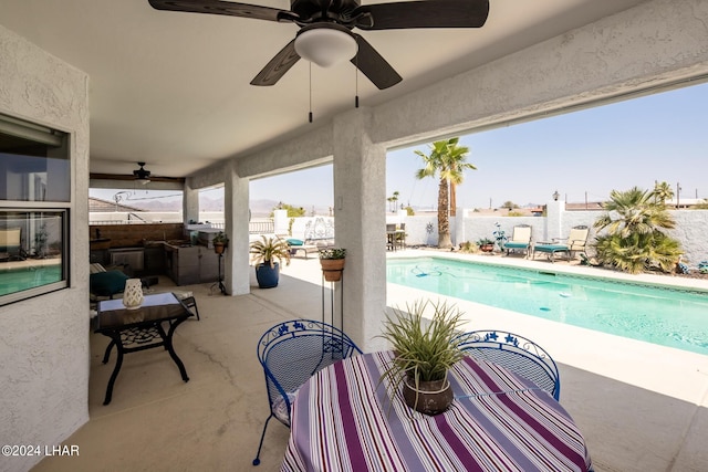 view of swimming pool featuring ceiling fan, exterior kitchen, and a patio