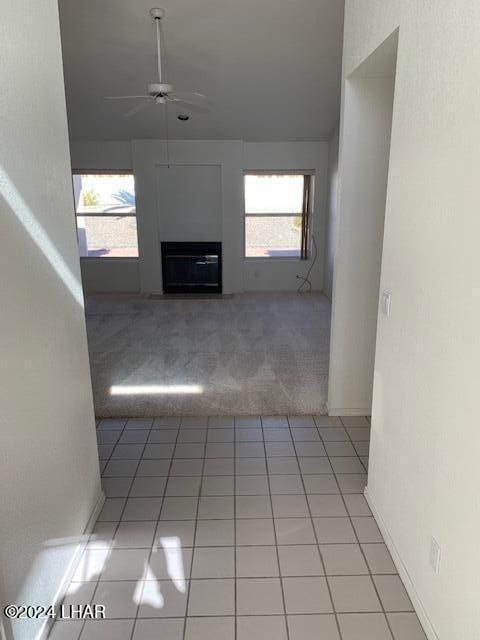 unfurnished living room with light carpet and ceiling fan