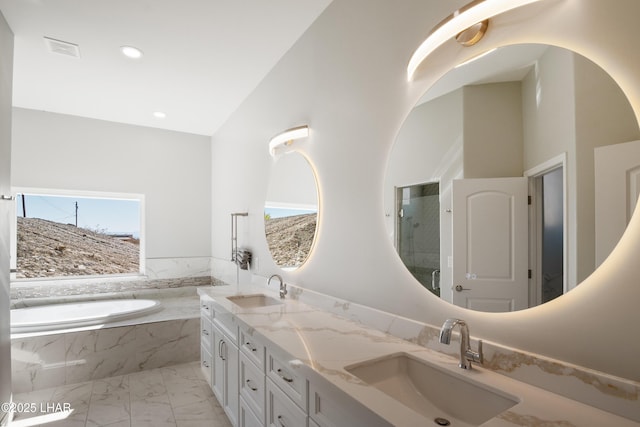 bathroom featuring visible vents, a bath, marble finish floor, and a sink