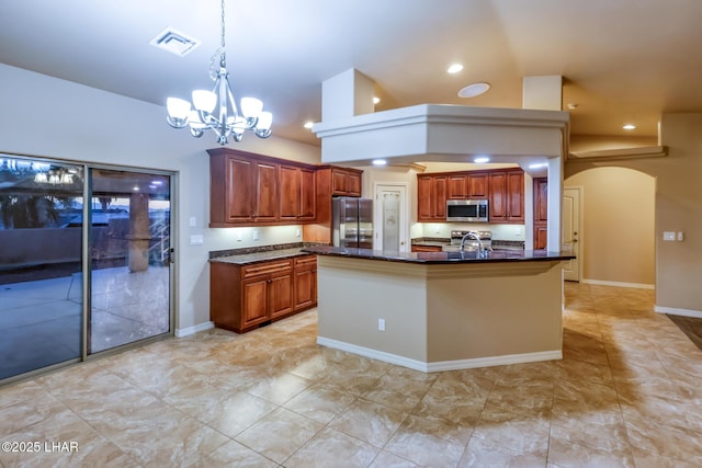 879 Window Rock Plz, Lake Havasu City, AZ 86406 - kitchen featuring appliances with stainless steel finishes, a chandelier, arched walkways, pendant lighting, and a center island with sink