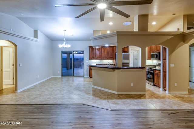 879 Window Rock Plz, Lake Havasu City, AZ 86406 - kitchen featuring appliances with stainless steel finishes, dark countertops, a ceiling fan, arched walkways, and brown cabinetry