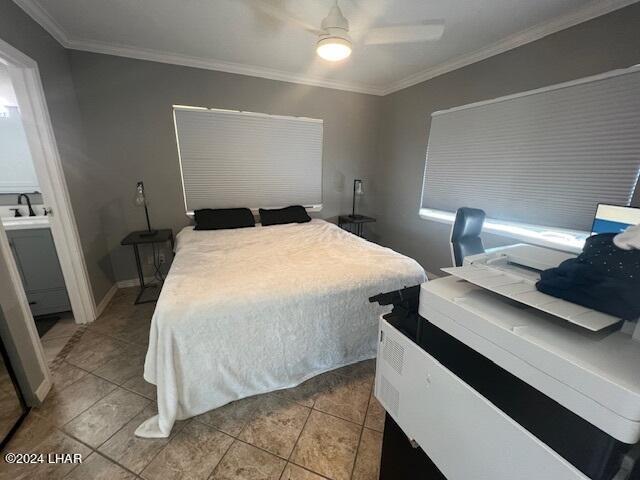 bedroom with sink, light tile patterned floors, ceiling fan, crown molding, and ensuite bath