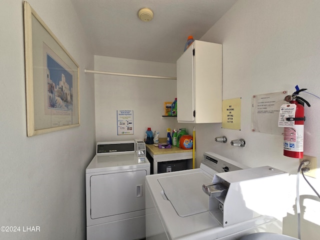 laundry room featuring cabinets and washing machine and clothes dryer