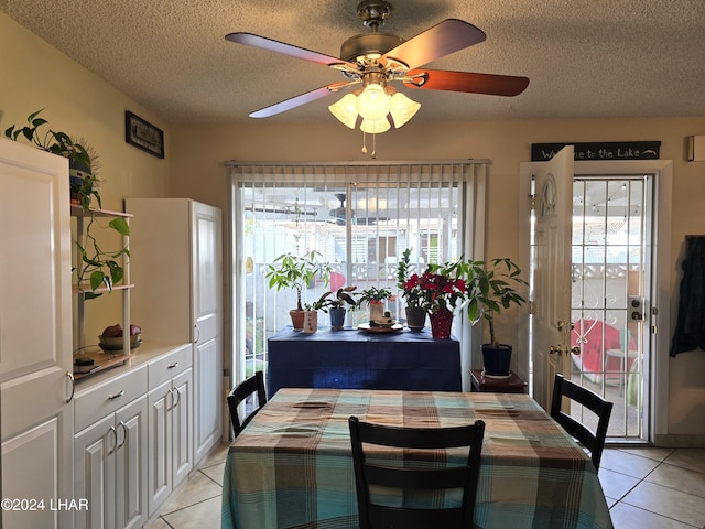 dining room featuring light tile patterned floors, a textured ceiling, and ceiling fan