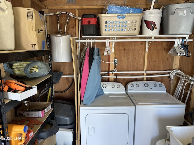 laundry area featuring wood walls and washer and clothes dryer