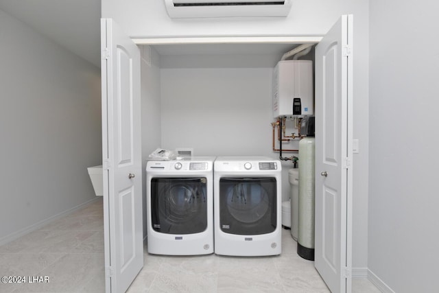 laundry area with independent washer and dryer, a wall mounted AC, and water heater