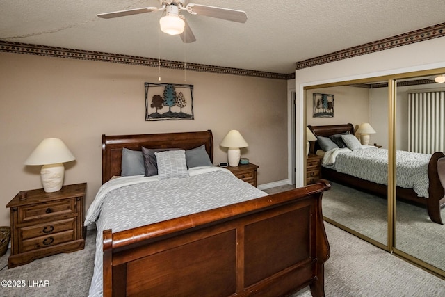 bedroom with a closet, carpet flooring, a textured ceiling, and ceiling fan