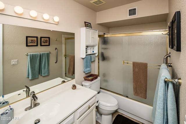 bathroom featuring vanity, toilet, visible vents, and enclosed tub / shower combo