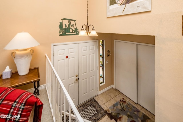 foyer with tile patterned flooring, baseboards, and an inviting chandelier