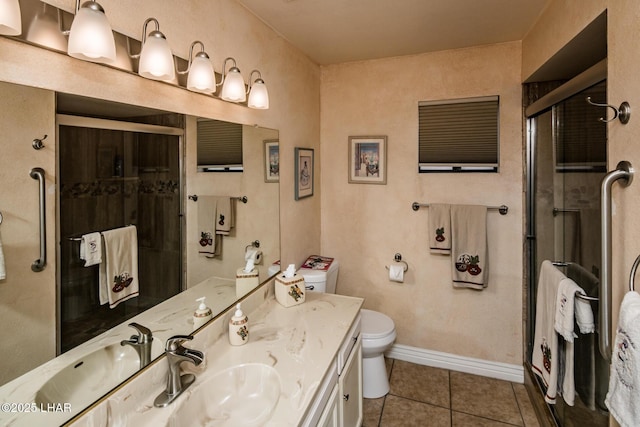 bathroom with vanity, baseboards, a shower stall, tile patterned floors, and toilet