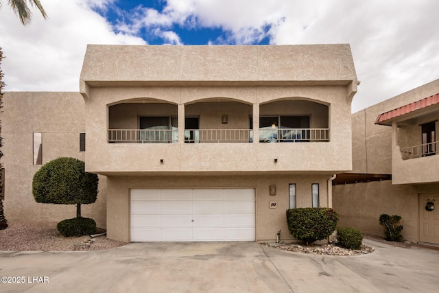 view of front of house with stucco siding, a garage, and driveway