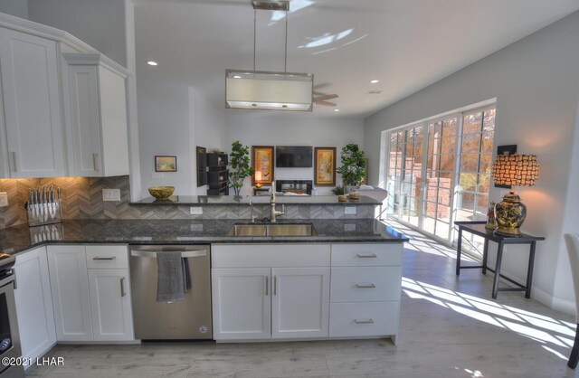 8551 River View Villas Dr Unit 15, Parker, AZ 85344 - kitchen featuring dishwasher, a sink, white cabinets, tasteful backsplash, and dark stone countertops