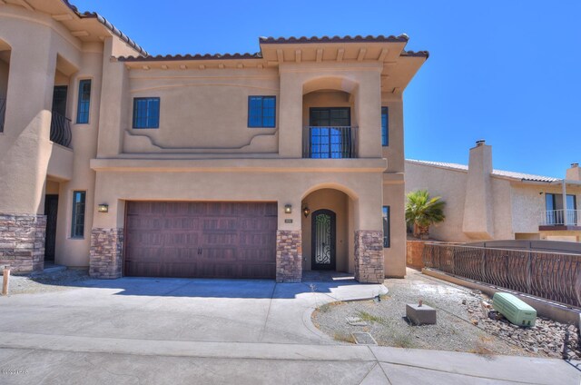 8551 River View Villas Dr Unit 15, Parker, AZ 85344 - view of front facade featuring an attached garage, stucco siding, driveway, stone siding, and a tiled roof