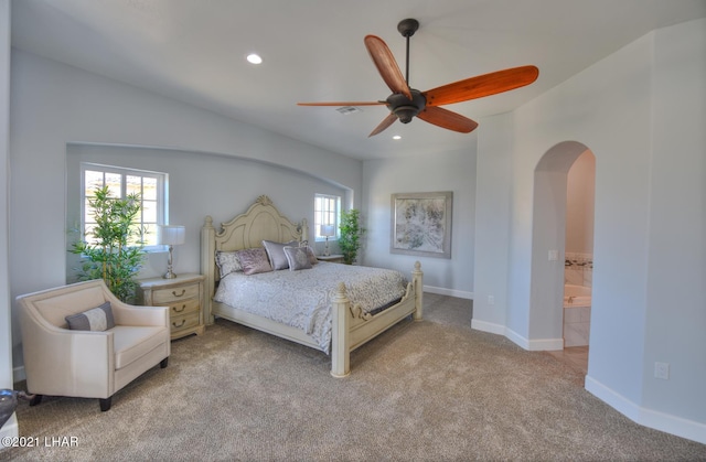 8551 River View Villas Dr Unit 15, Parker, AZ 85344 - bedroom with arched walkways, light colored carpet, recessed lighting, baseboards, and connected bathroom