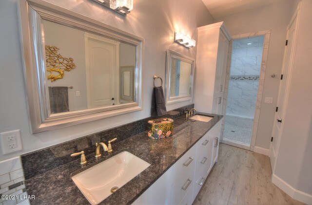 8551 River View Villas Dr Unit 15, Parker, AZ 85344 - bathroom with double vanity, a shower stall, wood finished floors, and baseboards