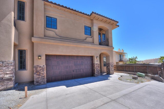 8551 River View Villas Dr Unit 15, Parker, AZ 85344 - view of front facade with stone siding, a garage, stucco siding, and driveway