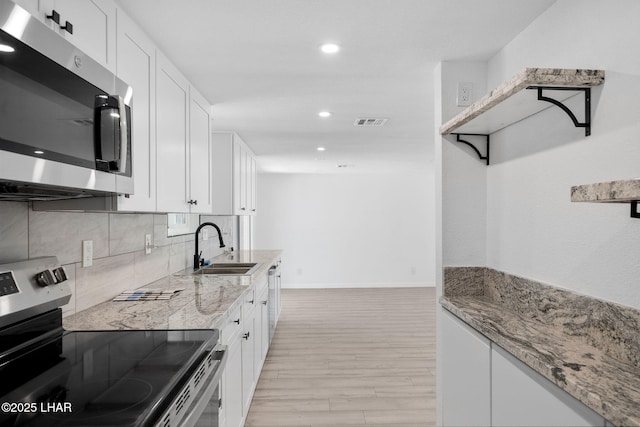 2870 Cisco Dr S, Lake Havasu City, AZ 86403 - kitchen with stainless steel appliances, light wood-style flooring, recessed lighting, white cabinets, and light stone countertops