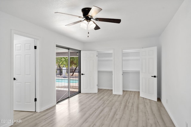 2870 Cisco Dr S, Lake Havasu City, AZ 86403 - unfurnished bedroom featuring access to outside, light wood-type flooring, two closets, and ceiling fan