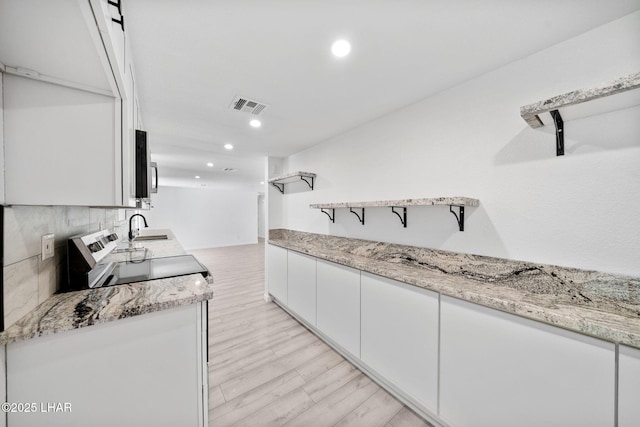 2870 Cisco Dr S, Lake Havasu City, AZ 86403 - kitchen with white cabinets, recessed lighting, stainless steel microwave, light wood finished floors, and open shelves