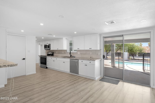 2870 Cisco Dr S, Lake Havasu City, AZ 86403 - kitchen featuring stainless steel appliances, tasteful backsplash, light wood-style flooring, white cabinets, and recessed lighting